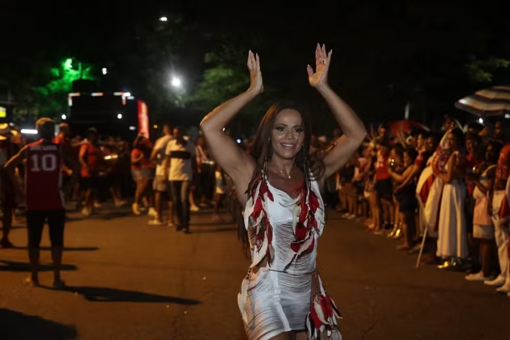 Noite de ensaios de rua com bateria, alas, porta-bandeira, intérpretes e muitos componentes.