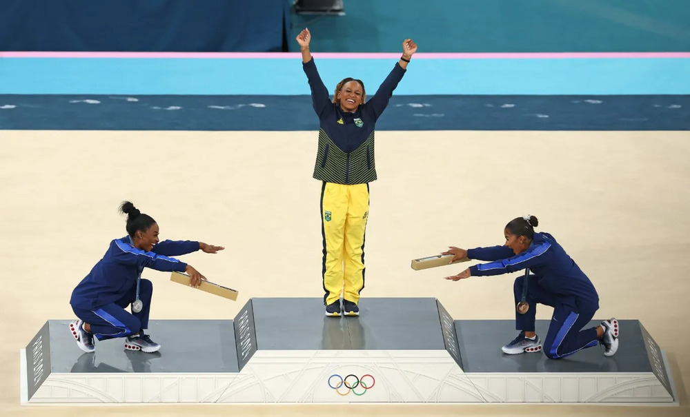 Web vai à loucura com foto de Simone Biles e Jordan Chiles reverenciando Rebeca Andrade no pódio